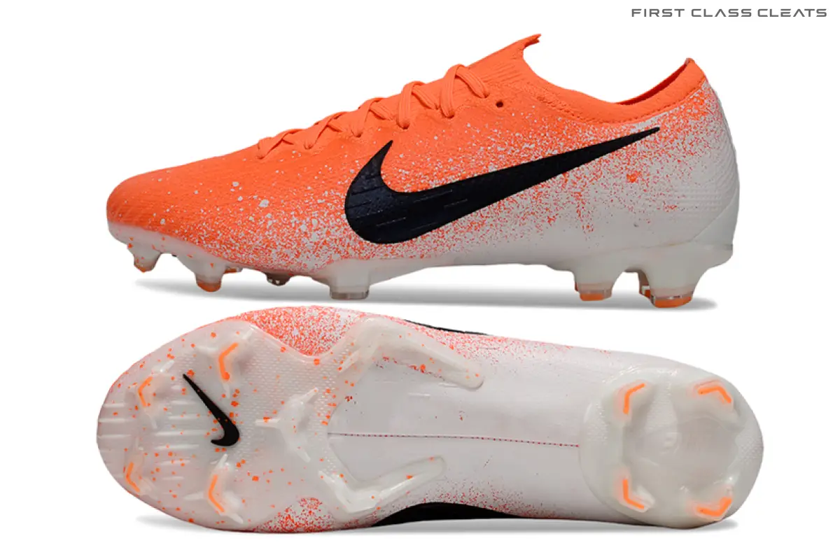 Side profile and full outsole of a Mercurial Vapor 12 Euphoria football boot, showing an orange forefoot, light grey heel, black swoosh and pale sole with orange speckles.