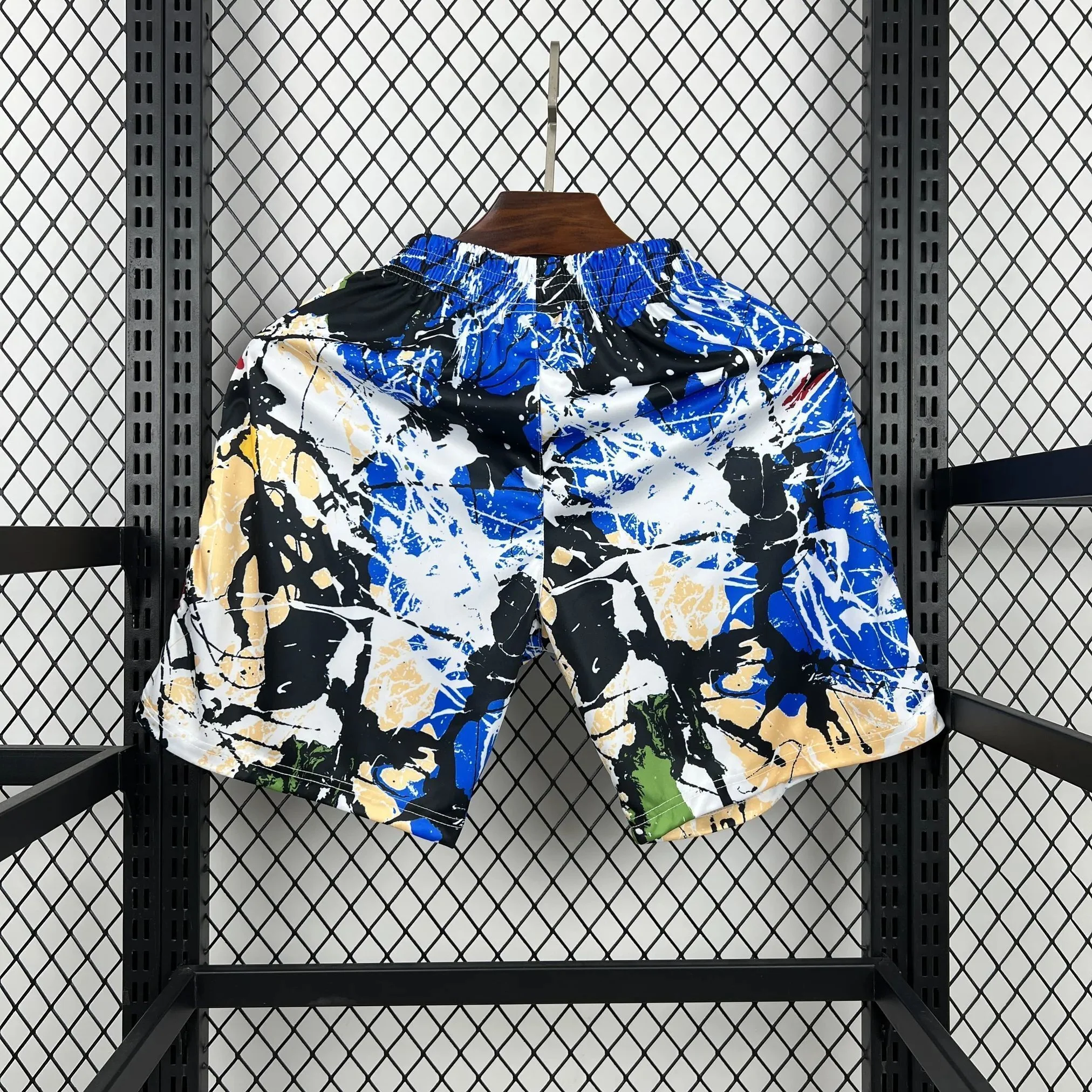 Back view of Manchester United graphic shorts with an all-over blue, white, black and pale yellow splatter-style pattern
