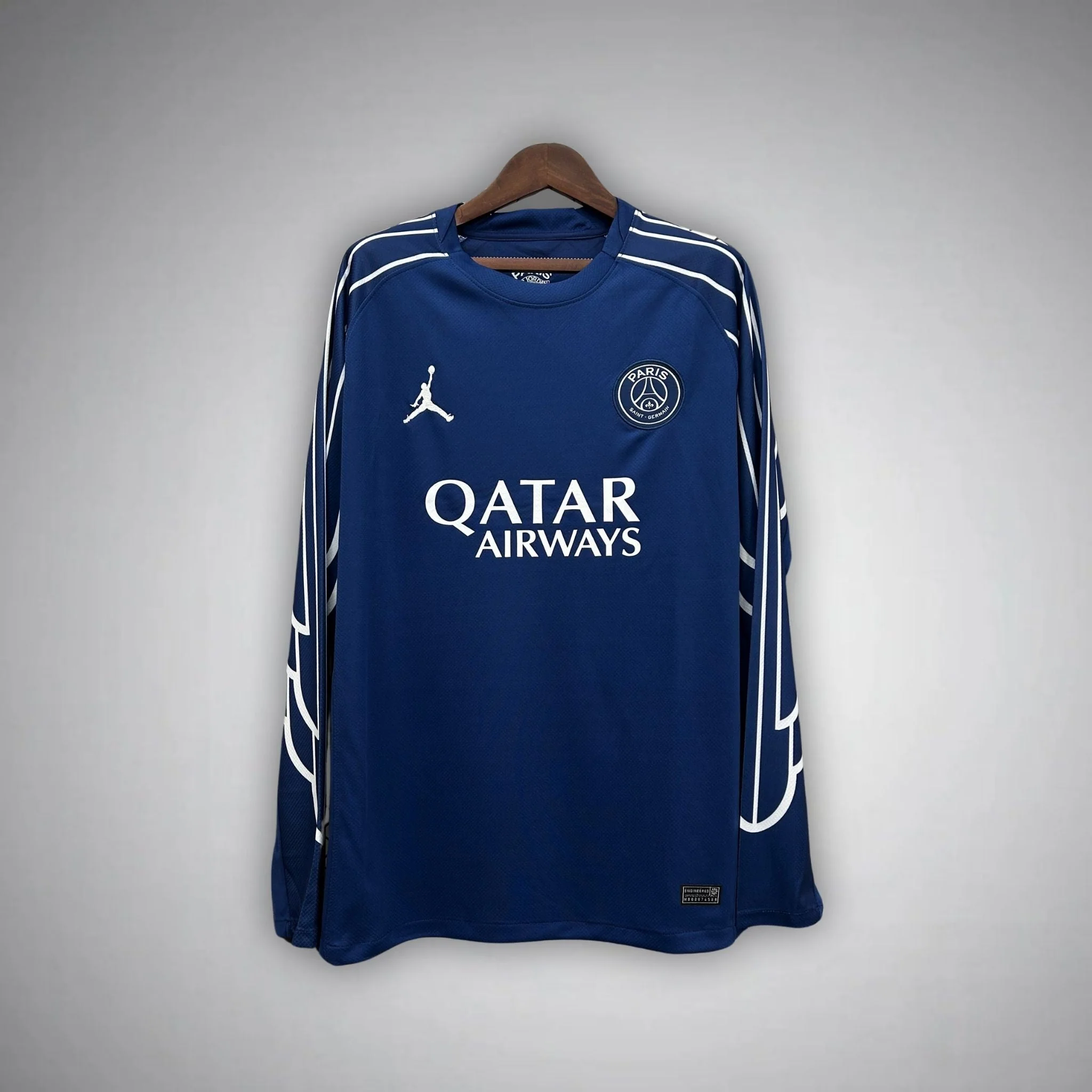 Blue PSG fourth long-sleeve shirt with white outlined shapes along the shoulders and sleeves