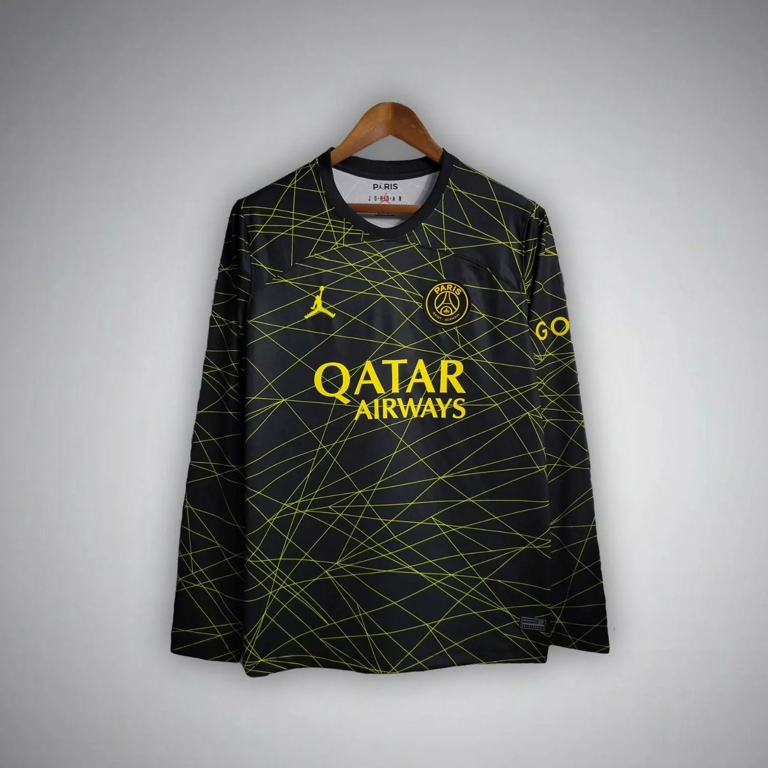 Black PSG fourth long-sleeve shirt covered in intersecting yellow lines with yellow Qatar Airways lettering