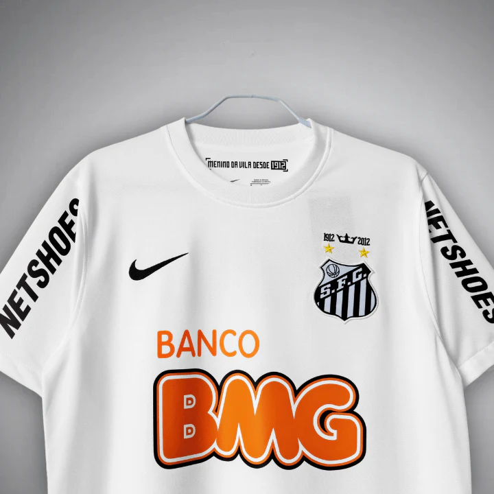 Upper-front detail of the Santos FC white shirt, showing the round collar, black swoosh, SFC crest with two gold stars and 1912-2012 detail, and orange BANCO BMG lettering