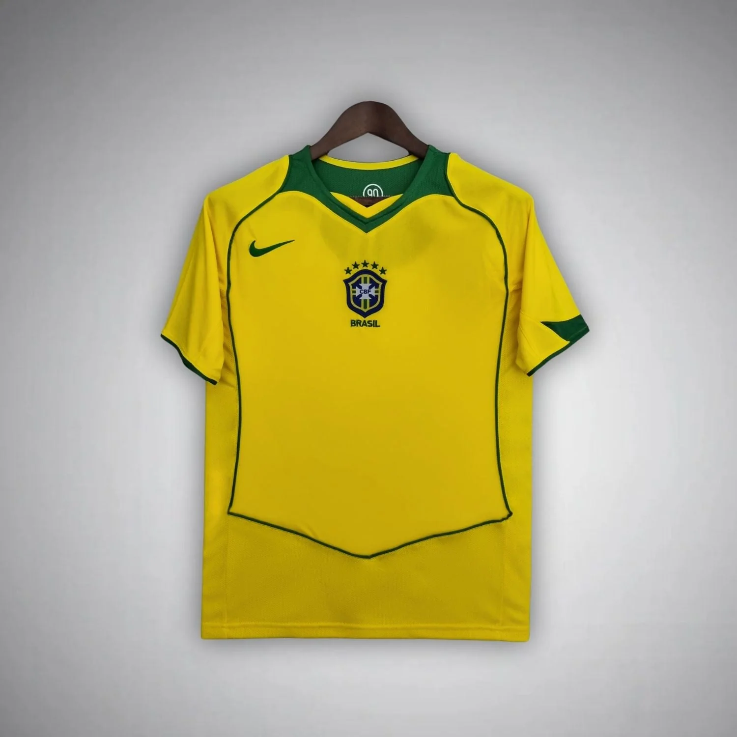 2004 Brazil home shirt with green V-neck, central crest and a thin large shield outline