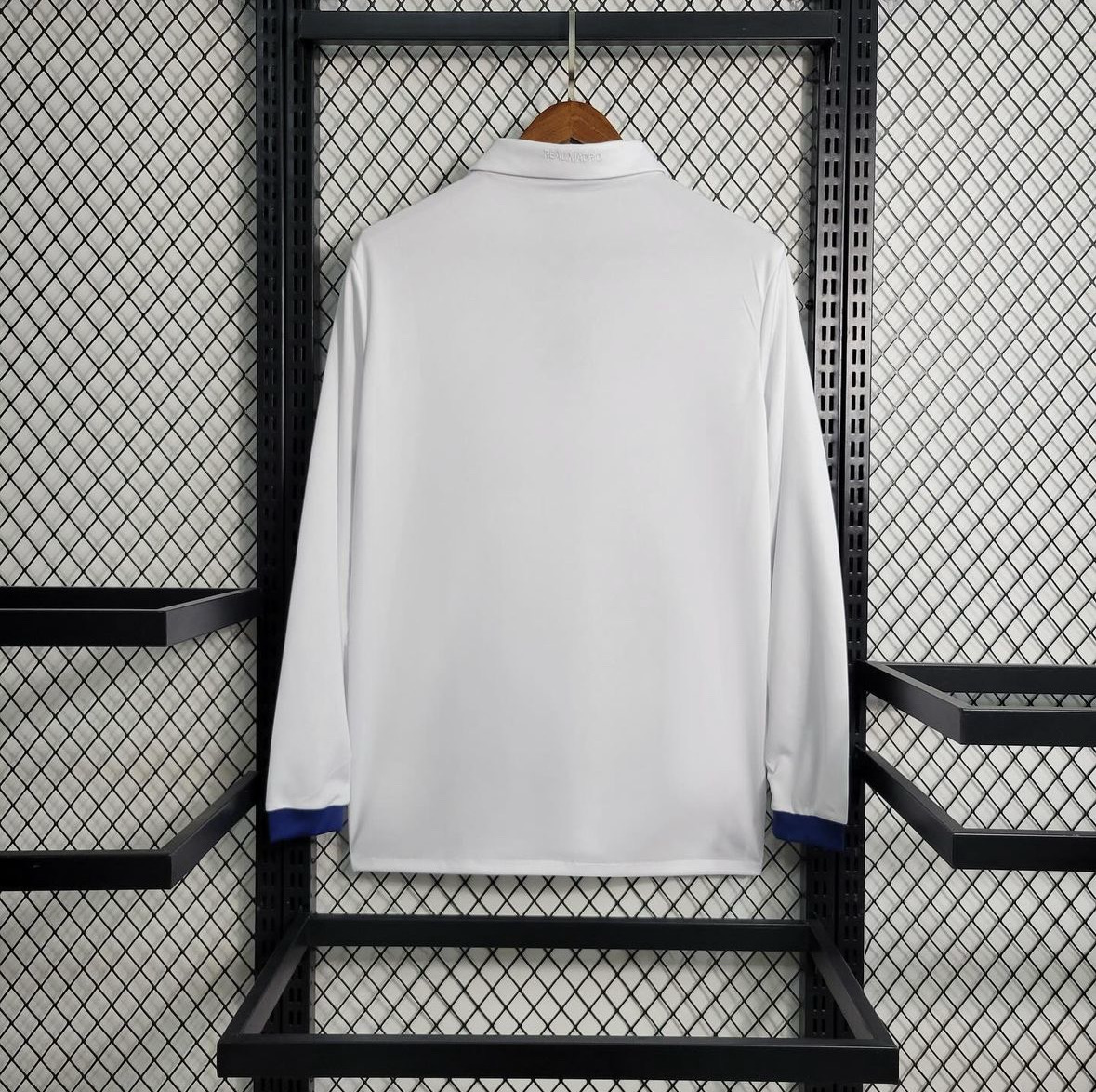 Real Madrid white long sleeve football shirt, plain back view with a white fold-over collar and blue sleeve cuffs