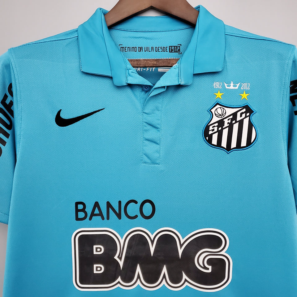 Close-up of the turquoise polo collar, Santos FC crest, black Nike swoosh and Banco BMG lettering on a retro football shirt.