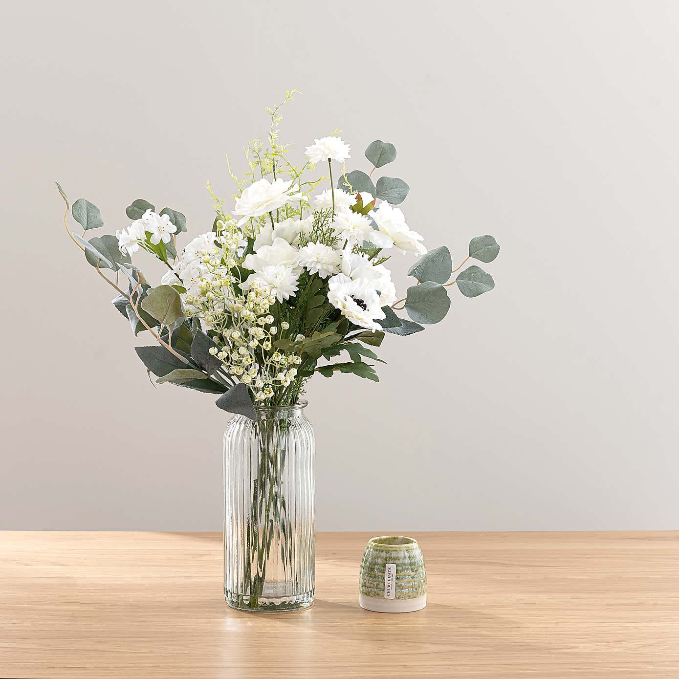 White Rose & Eucalyptus Floral Arrangement in Ribbed Glass Vase with Soft Amber & Pine Candle