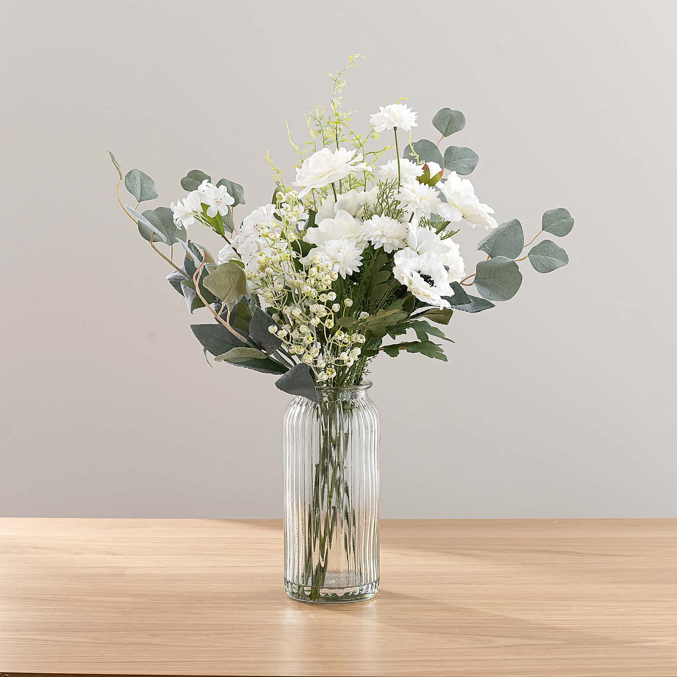White Rose & Eucalyptus Floral Arrangement in Ribbed Glass Vase with Soft Amber & Pine Candle